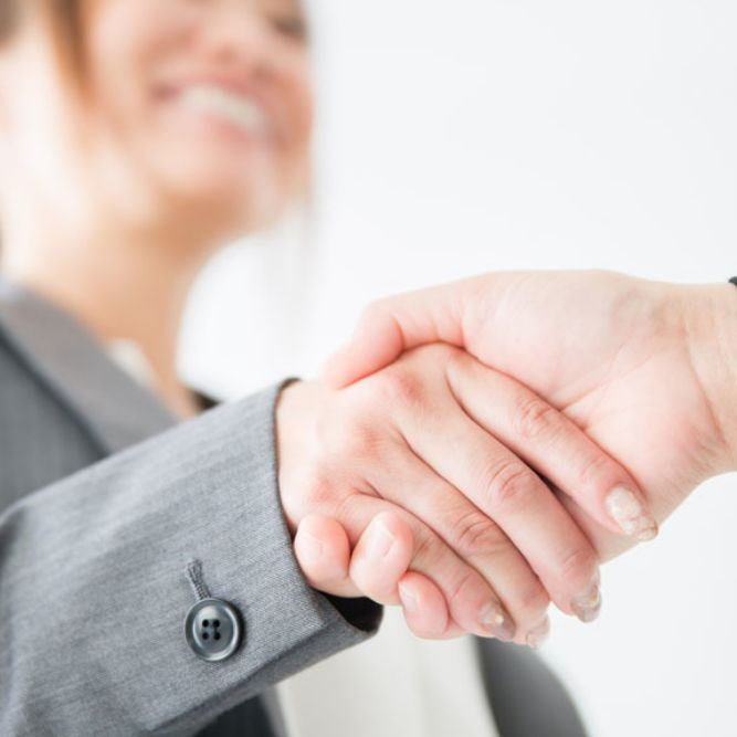 女性が握手をしている