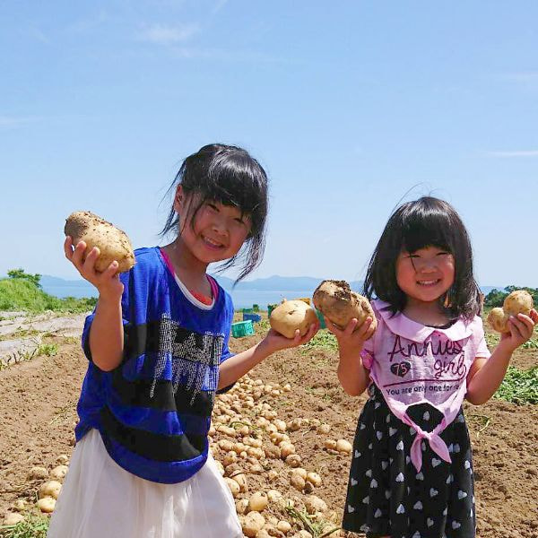 じゃがいもを両手で持つ二人の子ども